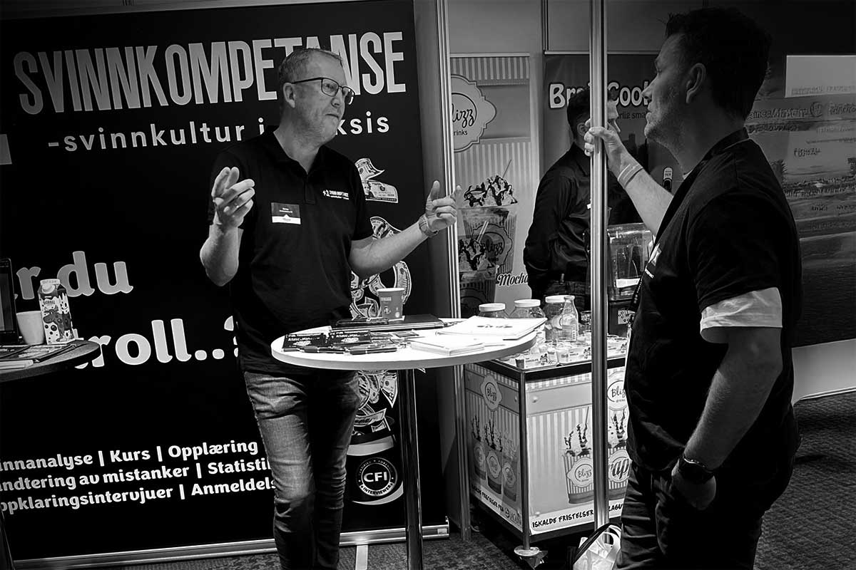 To menn diskuterer svinnkultur ved en stand.