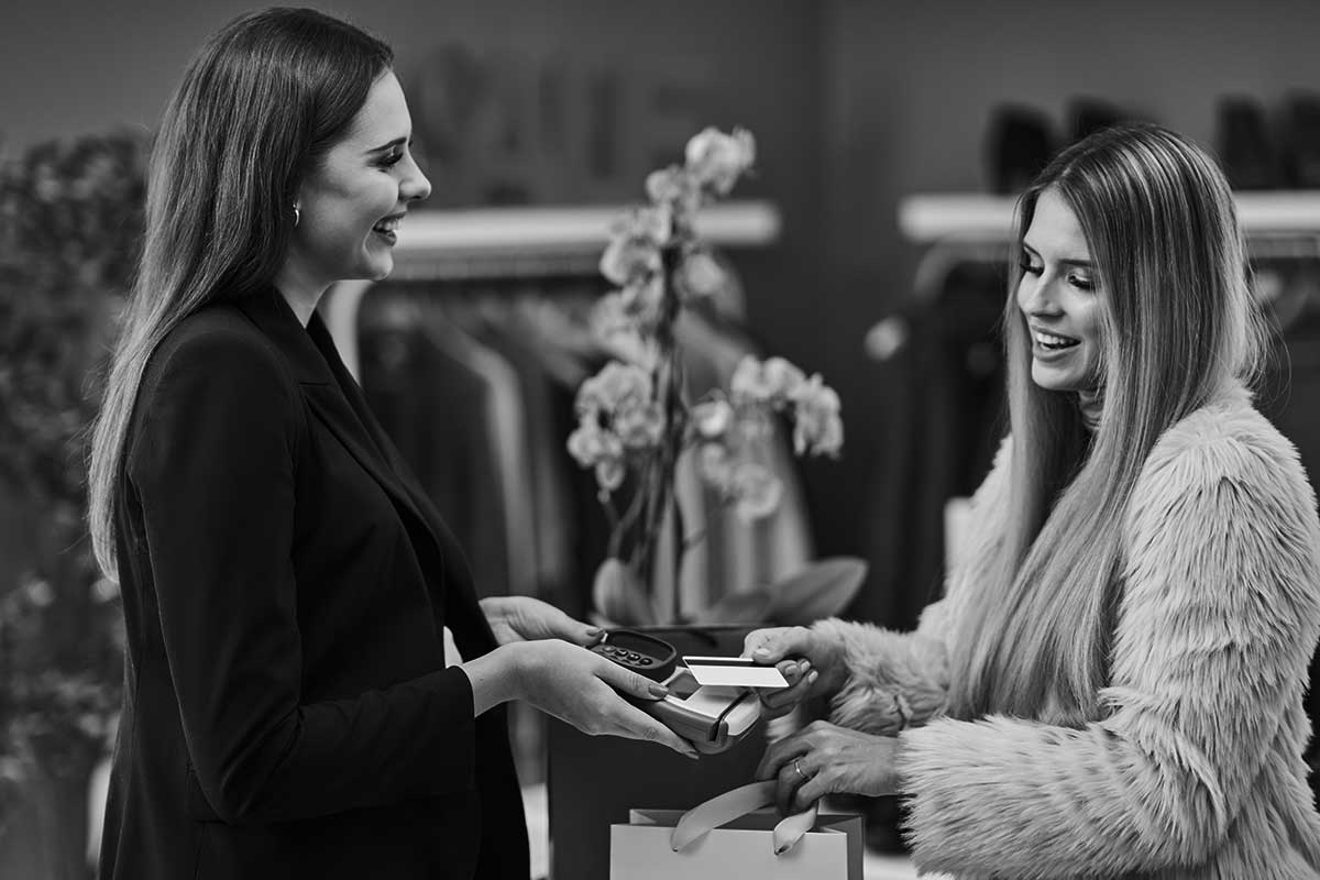 Person betaler med kort i klesbutikk